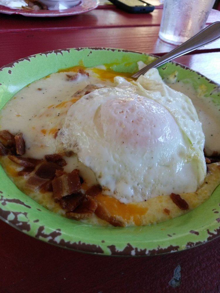 breakfast bowl with two eggs bacon grits sausage gravy and