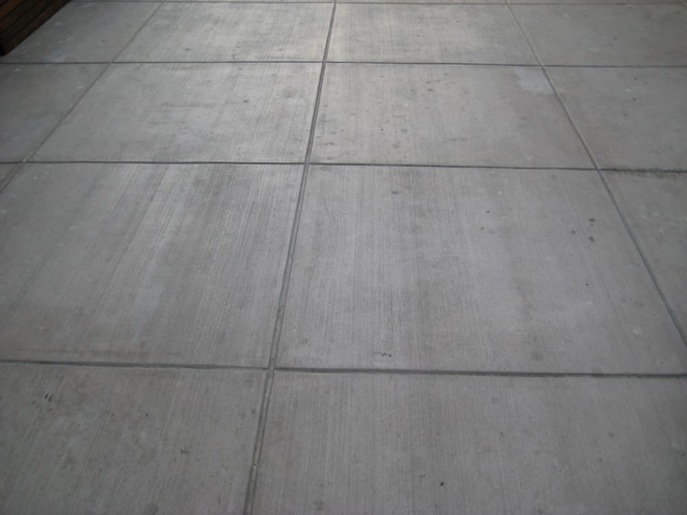 Colored concrete slab with broom finish and colored grouted joints to